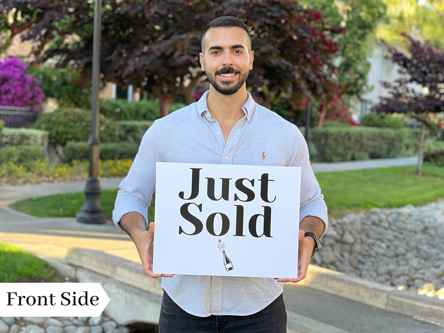 Realtor holding the front side of a rectangle Just Sold prop sign outdoors