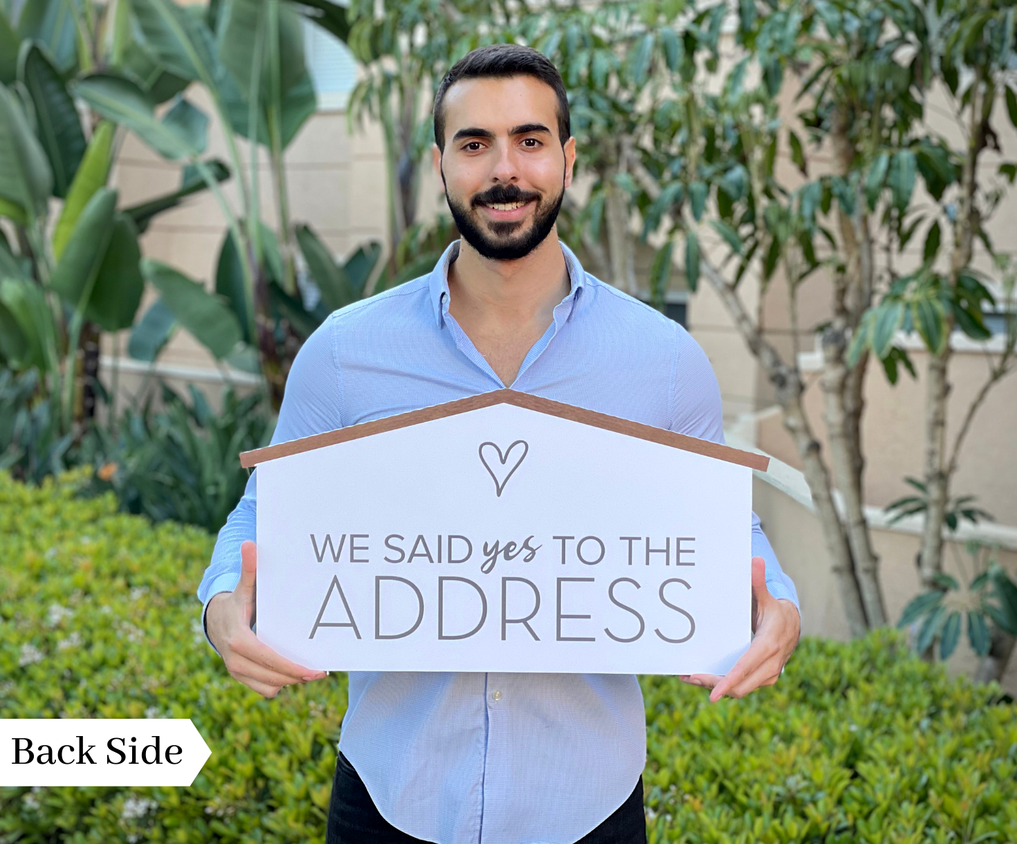 Realtor holding the back side of a 24 inch house-shaped We Said Yes to the Address prop sign outdoors