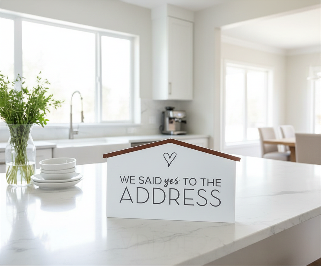 House-shaped We Said Yes to the Address prop sign displayed on a kitchen counter