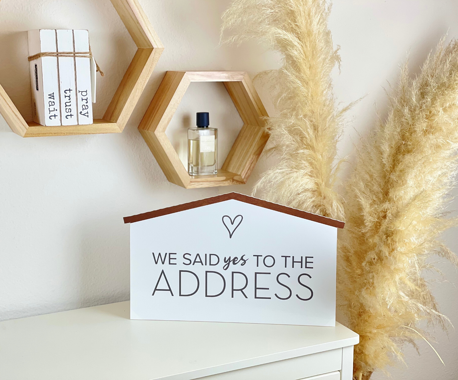 Rustic wood-style We Said Yes to the Address prop sign displayed as home decor with pampas grass